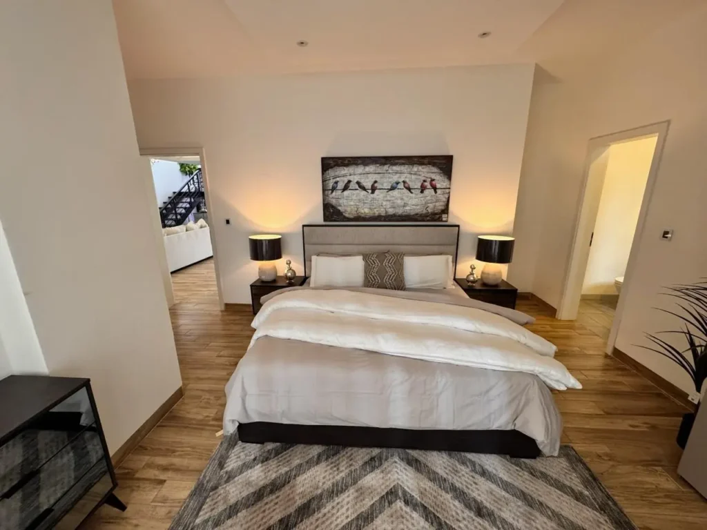 Stylish bedroom suite with feature artwork, warm lighting and premium finishes at Rumaisa Residency, Nairobi.