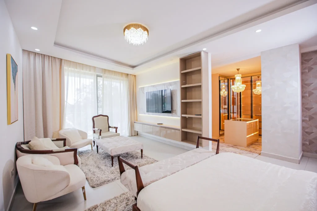 Spacious master bedroom at J & M Palms Residence Nairobi with walk-in closet, chandelier lighting, TV wall and premium finishes.